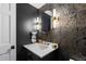 Stylish powder room showcases gold accents, unique wallpaper, and a modern mirror at 5955 Blue Sage Way, Littleton, CO 80123