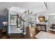 Bright foyer with a curved staircase, hardwood floors, and an elegant round mirror at 5955 Blue Sage Way, Littleton, CO 80123