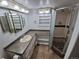 Bathroom with a vanity, multiple mirrors, and glass enclosed tiled shower at 3136 S Cathay Cir, Aurora, CO 80013