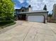 Two-story home featuring an attached garage, brick accents, and a large driveway at 3136 S Cathay Cir, Aurora, CO 80013