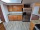 Kitchen with stainless steel refrigerator, granite countertops and wooden cabinetry, offering ample storage at 3136 S Cathay Cir, Aurora, CO 80013
