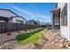 Side yard showing putting green and covered patio with hot tub at 11492 Stonewash St, Littleton, CO 80125