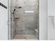 Modern walk-in shower with gray tile and a glass door at 11492 Stonewash St, Littleton, CO 80125