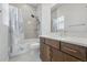 Modern bathroom featuring a shower and tub combination with glass doors and wood cabinets at 11492 Stonewash St, Littleton, CO 80125