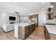 Open kitchen with a large island, stainless appliances, and view of the living room fireplace at 11492 Stonewash St, Littleton, CO 80125