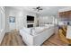 Open-concept living space featuring hardwood floors, a fireplace, and a glimpse of the staircase and kitchen at 11492 Stonewash St, Littleton, CO 80125