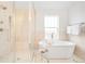 Bright bathroom features a glass-enclosed shower and free standing soaking tub at 418 S Gilpin St, Denver, CO 80209