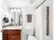 Well-lit bathroom featuring wood vanity, decorative mirror, and combination tiled shower at 418 S Gilpin St, Denver, CO 80209