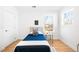 Bright bedroom with hardwood floors, twin bed, stylish decor, and a sunlit window view at 418 S Gilpin St, Denver, CO 80209