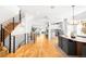 Open-concept living area with hardwood floors, a modern staircase, and seamless transitions to the dining and kitchen at 418 S Gilpin St, Denver, CO 80209