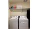 Functional laundry room with a washer and dryer, and storage shelves at 1109 Sunrise Dr, Lochbuie, CO 80603