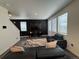 Modern living room featuring a black accent wall, plush seating, and an eye-catching area rug at 1109 Sunrise Dr, Lochbuie, CO 80603