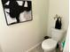 Powder room with toilet, modern art, and decorative accents at 1109 Sunrise Dr, Lochbuie, CO 80603