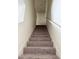 Carpeted staircase leading to the upper level of the home, with white banisters at 1109 Sunrise Dr, Lochbuie, CO 80603