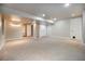 Large basement rec room with neutral carpet and ample lighting plus shelving and white trim at 2550 Winding River Dr # E1, Broomfield, CO 80023