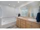 Well-lit bathroom featuring a soaking tub, double vanity, and modern fixtures for a spa-like experience at 2550 Winding River Dr # E1, Broomfield, CO 80023