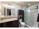 Bathroom with dark cabinets, granite countertops, tile floors and a glass enclosed shower at 2550 Winding River Dr # E1, Broomfield, CO 80023