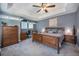 Comfortable bedroom with neutral tones, a large window, an adjacent office nook and a ceiling fan at 2550 Winding River Dr # E1, Broomfield, CO 80023