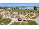 Aerial view of a scenic playground with multiple play structures, trails, and a lake in the background at 2550 Winding River Dr # E1, Broomfield, CO 80023