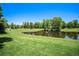 Serene pond with lush greenery and mature trees at 2550 Winding River Dr # E1, Broomfield, CO 80023