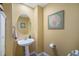 Charming powder room features a pedestal sink, decorative mirror, and artistic wall decor adding a touch of elegance at 2550 Winding River Dr # E1, Broomfield, CO 80023