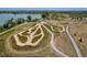 Aerial shot of a unique dirt recreation area with meandering trails and greenery near a lake at 2550 Winding River Dr # E1, Broomfield, CO 80023