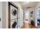 Hallway view of stacked washer and dryer with tiled bathroom and wood floors visible at 2841 N Columbine St, Denver, CO 80205