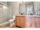 Clean bathroom featuring double sinks, tiled floors, and a glass-enclosed shower for convenience at 9335 Amison Cir # 203, Parker, CO 80134