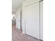 Hallway with neutral carpet and white trim leading to a kitchen and a closet at 1718 S Flanders Way, Aurora, CO 80017
