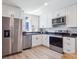 Modern kitchen with stainless steel appliances, white cabinets, and solid countertops at 1718 S Flanders Way, Aurora, CO 80017