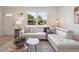 Bright living room featuring hardwood floors, a modern sofa, and a large window at 1718 S Flanders Way, Aurora, CO 80017