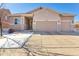 House exterior featuring a three-car garage and snow-covered front yard at 20150 E Fair Ln, Centennial, CO 80016