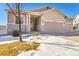 Tan two-story house with stone accents, two-car garage, and snowy front yard at 20150 E Fair Ln, Centennial, CO 80016