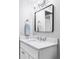 Bright bathroom featuring a white marble countertop, modern fixtures, and a rectangular mirror at 909 N Logan St # 3A, Denver, CO 80203