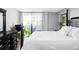 Bedroom with four post bed, hardwood floors, black dresser, and sliding glass door to a balcony at 909 N Logan St # 3A, Denver, CO 80203