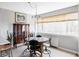 Bright dining area with glass table, modern chairs, window with blinds, and artwork at 909 N Logan St # 3A, Denver, CO 80203