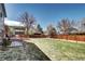 Large backyard featuring a deck area, mature trees, and a privacy fence at 13915 W 73Rd Ave, Arvada, CO 80005