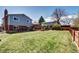 Expansive backyard features a spacious lawn, deck, and privacy fence at 13915 W 73Rd Ave, Arvada, CO 80005