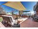 Outdoor deck with shade features comfortable seating, dining, and a well-manicured lawn at 13915 W 73Rd Ave, Arvada, CO 80005