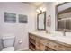Bathroom features a dual sink vanity with open storage and two mirrors at 13915 W 73Rd Ave, Arvada, CO 80005