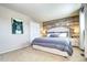 Bedroom features a padded headboard, rustic wood accent wall, and side tables with lamps at 13915 W 73Rd Ave, Arvada, CO 80005