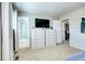 Bright bedroom with two dressers, a TV, and access to the bathroom at 13915 W 73Rd Ave, Arvada, CO 80005