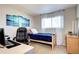 This bedroom boasts a twin bed, large desk, and a calming ocean-themed art piece at 13915 W 73Rd Ave, Arvada, CO 80005