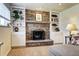 Close up of the stone fireplace with hearth and mantle, custom shelving, and built-in cabinets at 13915 W 73Rd Ave, Arvada, CO 80005