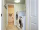 Laundry room with side-by-side washer and dryer, tiled floor, and access to a small bathroom at 13915 W 73Rd Ave, Arvada, CO 80005