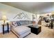 Living room with a sectional sofa, an ottoman, and a mountain mural on the wall at 13915 W 73Rd Ave, Arvada, CO 80005