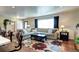 Spacious living room with a large sectional sofa and a floral rug, filled with natural light at 13915 W 73Rd Ave, Arvada, CO 80005