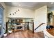 Bright living space with wood floors, a glass railing, many plants, and a view into another room at 13915 W 73Rd Ave, Arvada, CO 80005