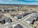 Wide aerial view showing homes, a paved walking trail, and natural terrain under a vibrant sky at 6977 Copper Sky Cir, Castle Pines, CO 80108