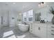 Bright bathroom with modern tub, double sinks, white marble flooring, and black fixtures at 6977 Copper Sky Cir, Castle Pines, CO 80108